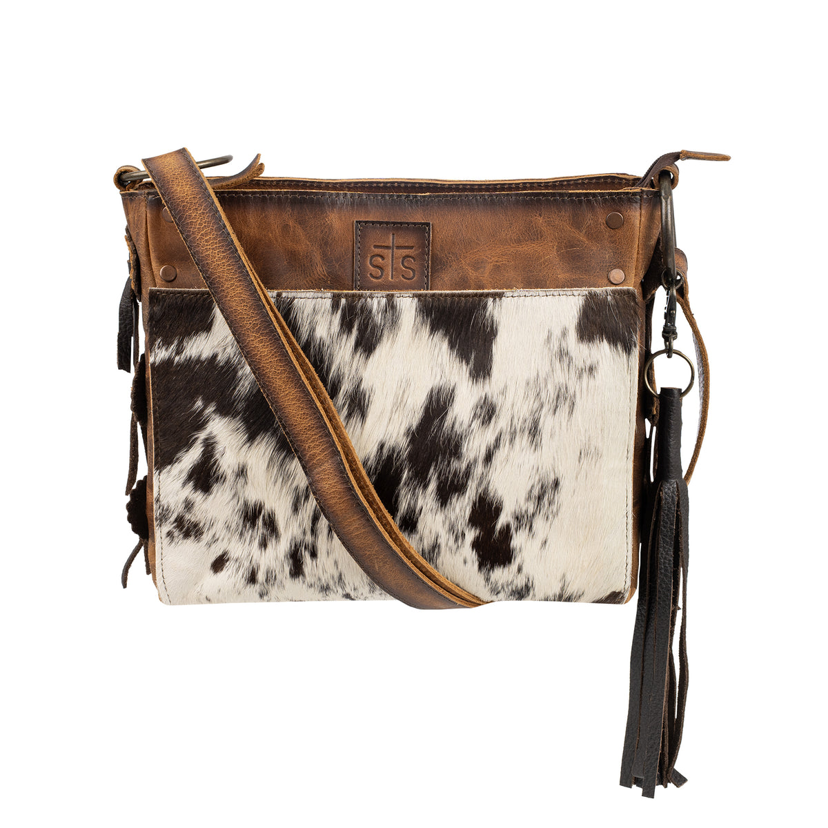 Cowhide and distressed full grain leather purse with top zip closure, magnetic front pocket, adjustable crossbody strap and removable tassel on white background