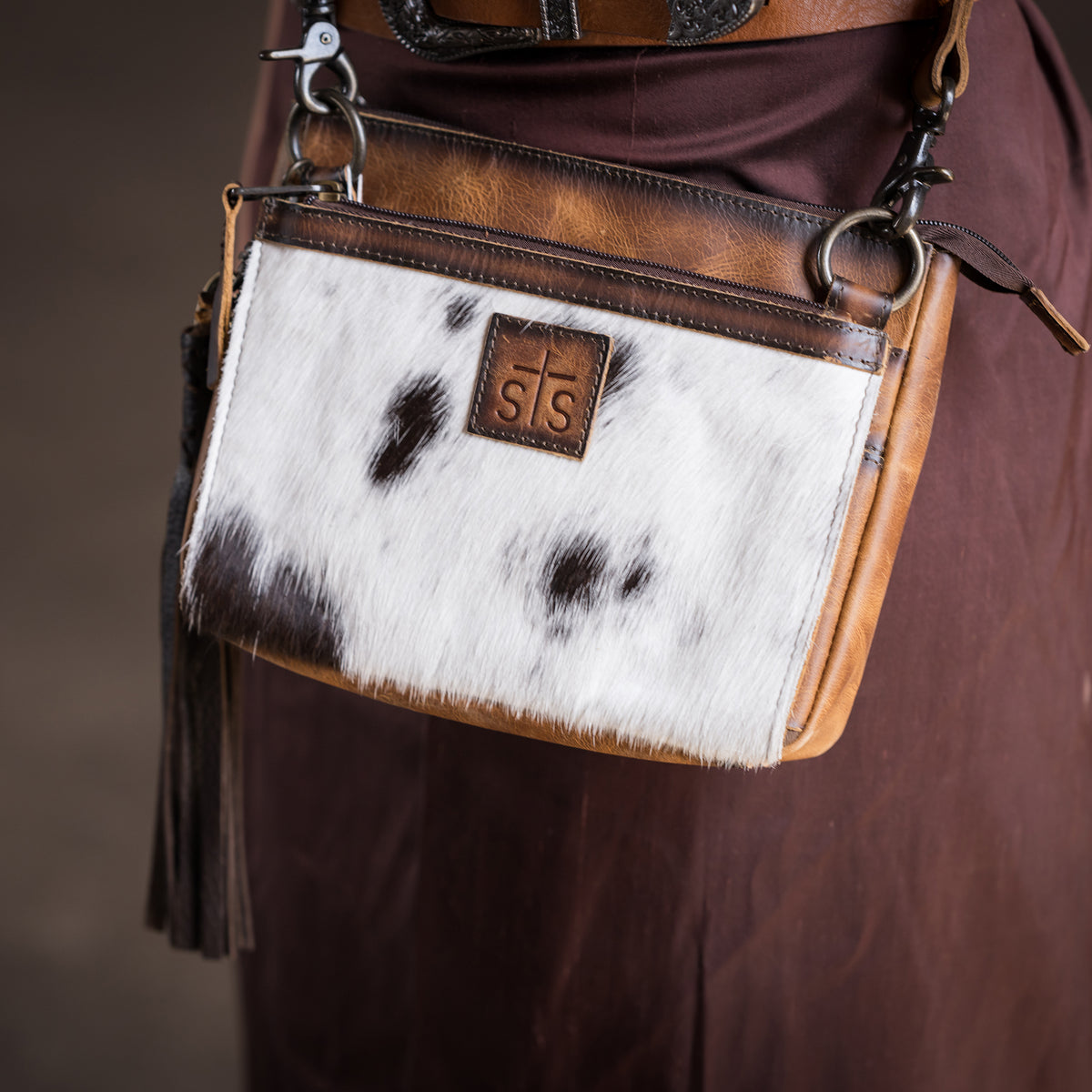 closeup of our Cowhide and distressed full grain leather purse with multiple zip closures and adjustable crossbody strap on a woman's hip