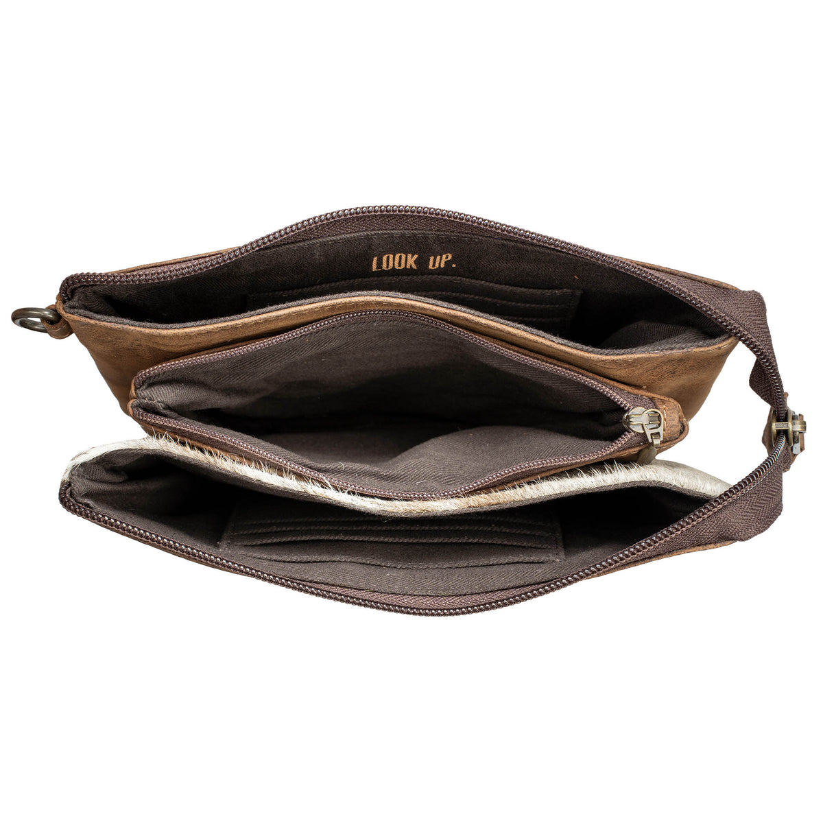 Overhead view of a cowhide and leather crossbody purse fully opened on a white background. 
