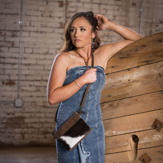 Yaleigh Yarbrough in a denim dress wearing a cowhide and STS embossed leather crossbody purse.