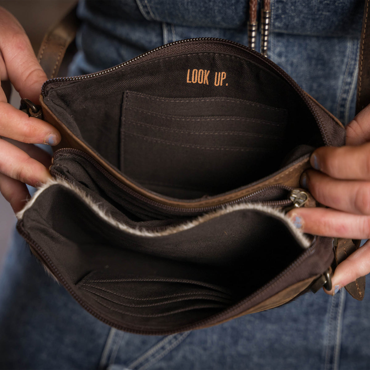 "Look Up." gold lettering printed in the lining of a leather crossbody purse.