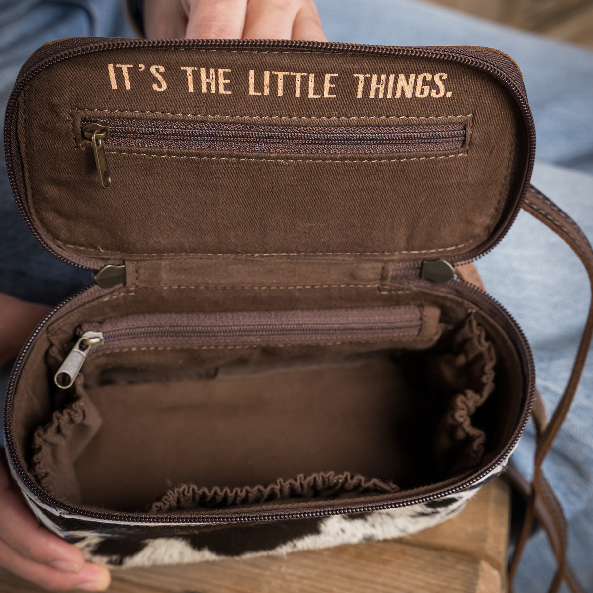 inside view of our our leather and cowhide petite train case with double zip closure with tassels and a top carry handle on white background 