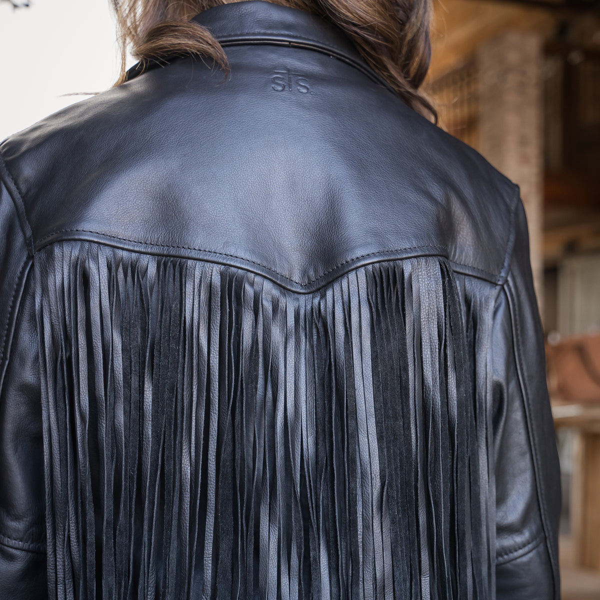 back of our black leather jacket with fringe detailing and asymmetrical zipper front closure