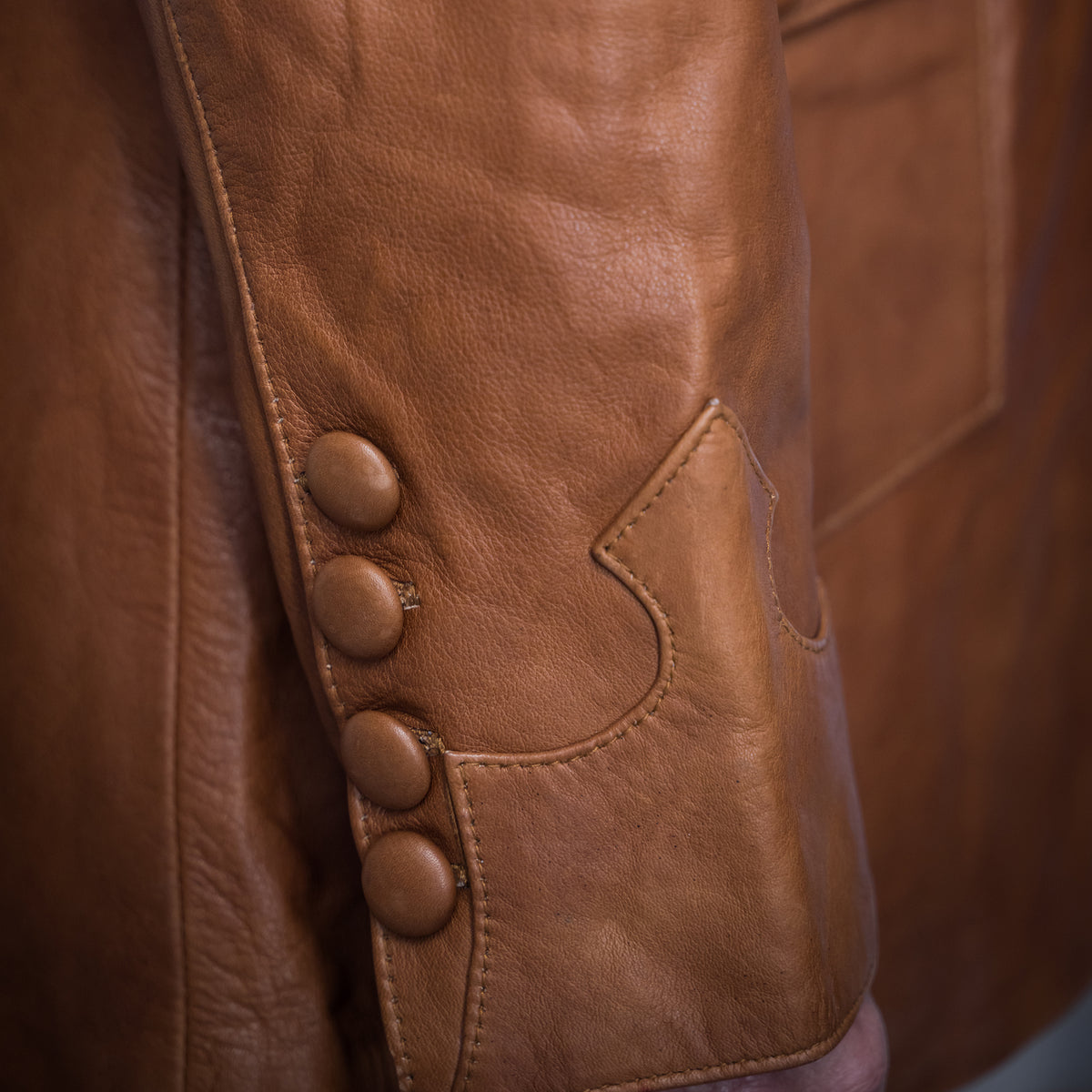 Closeup of the cuff on a brown genuine leather jacket.