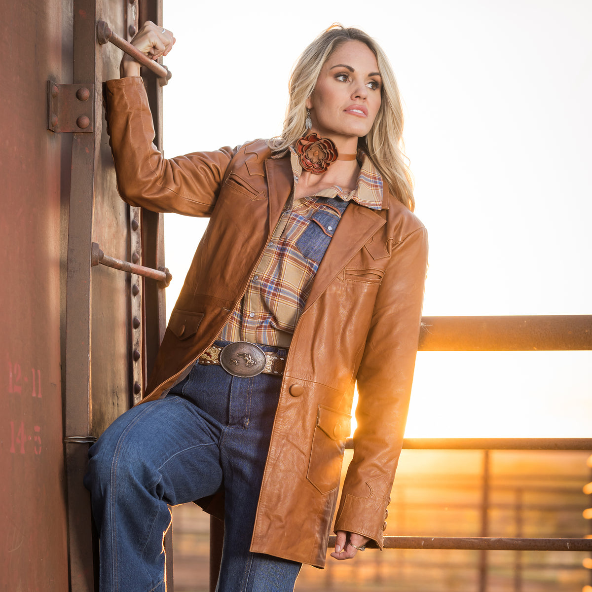 Terryn Cooper wearing a brown leather jacket with front button closure and two buttoned waist pockets in an outdoor setting.