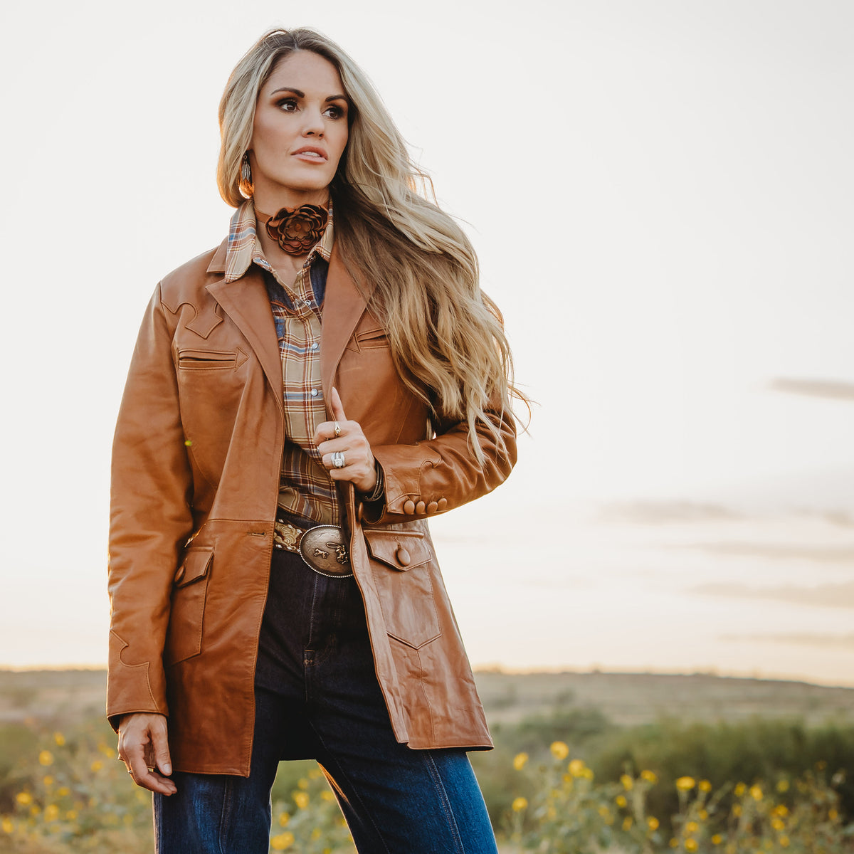 Terryn Cooper wearing a brown genuine leather jacket in an outdoor setting.
