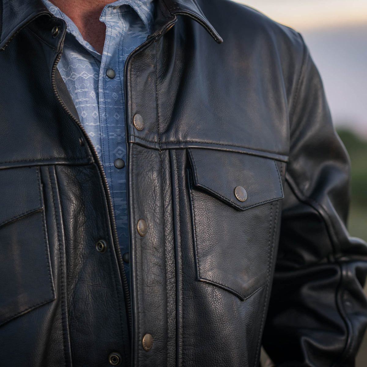 Detail view of genuine leather black Rancher jacket with snap closure pockets.
