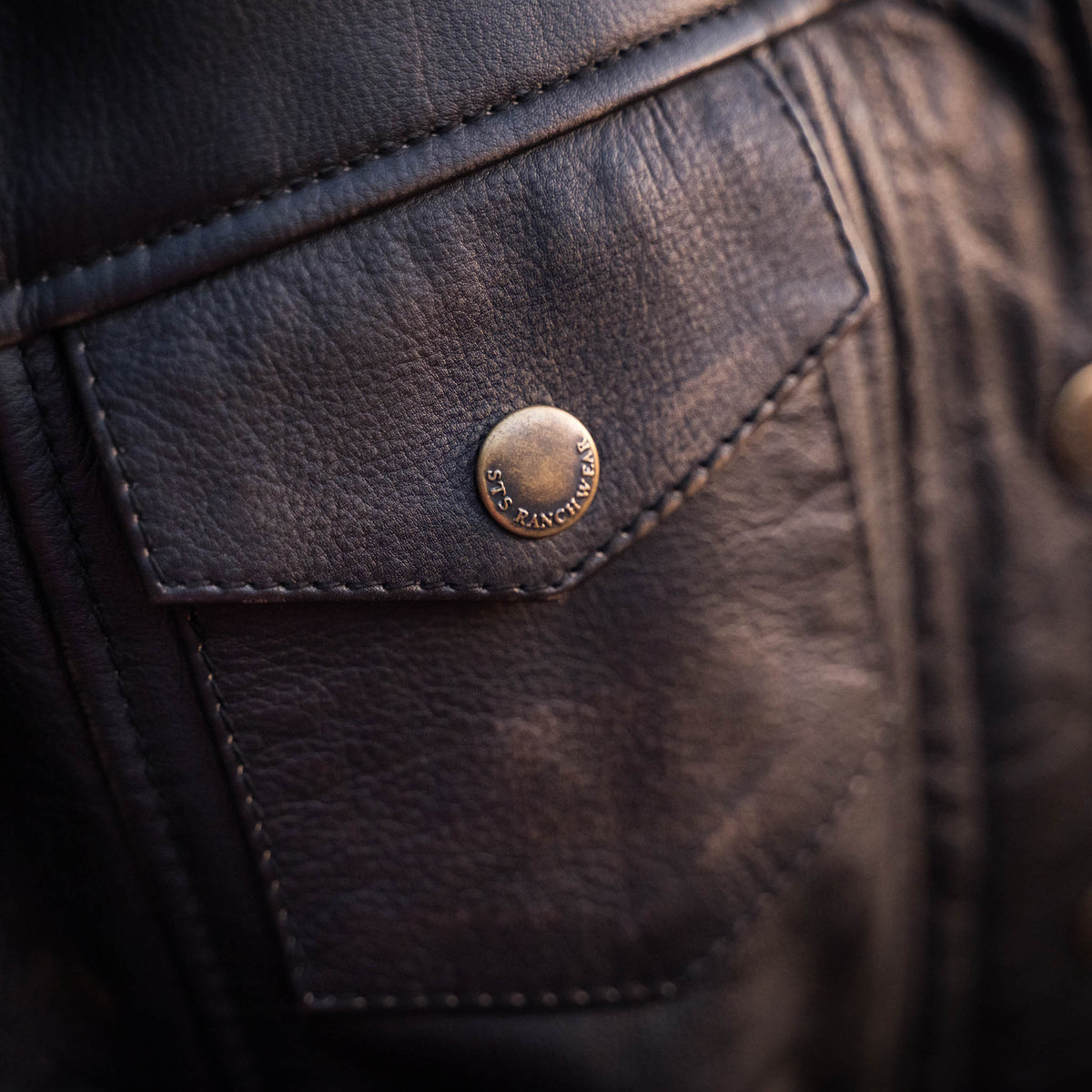 Detail of genuine leather jacket with snap closure chest pocket.