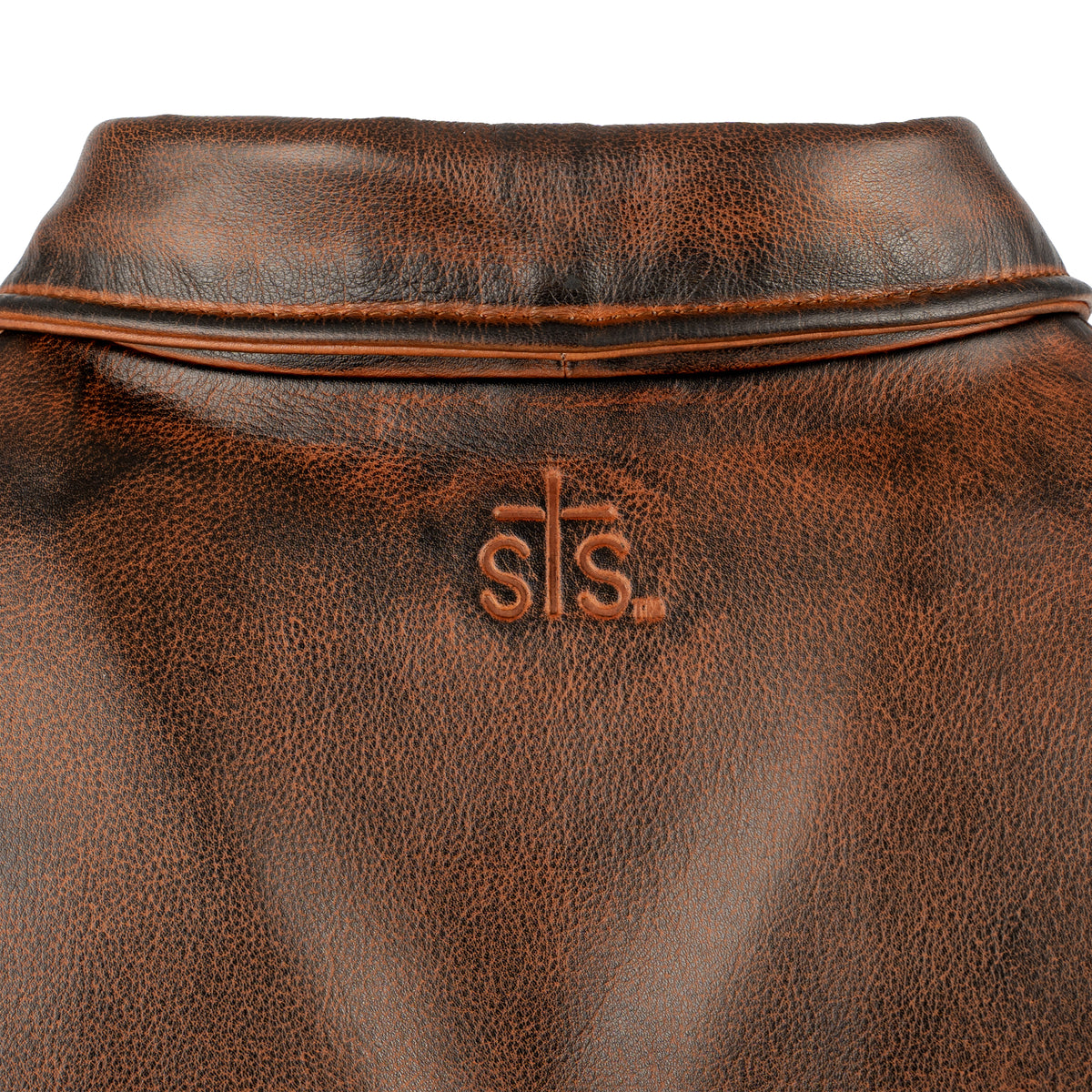 closeup of sts embossed leather yoke on our deep bay leather jacket with a front zipper, classic western yoke and hand warming pockets on white background