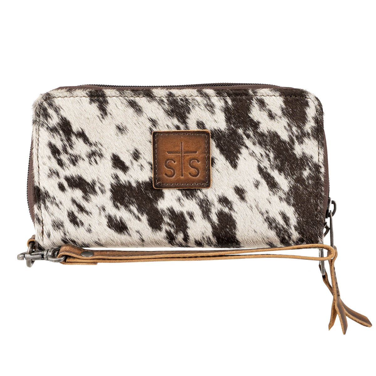 A cowhide wallet with a brown and white pattern, featuring a leather wristlet strap and the 'STS' brand logo embossed on a leather patch.