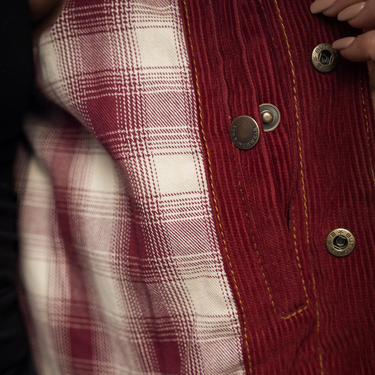 closeup of the interior conceal carry compartment of our red cotton corduroy snap closure jacket with two chest pockets and leather collar details 