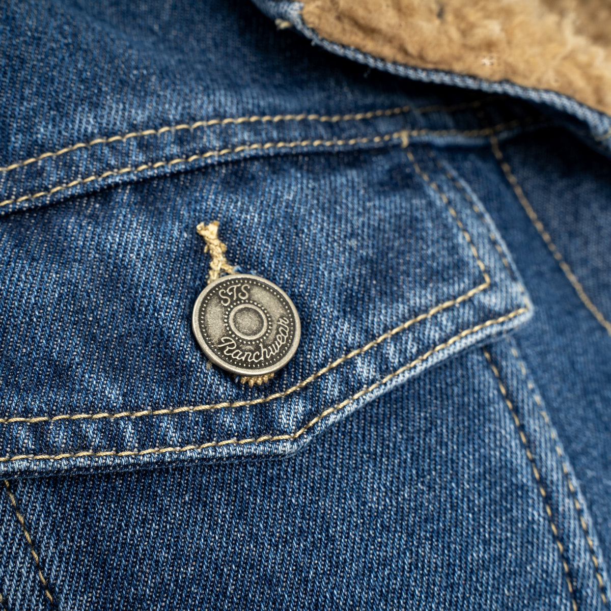 closeup of the chest pocket on our light wash denim lined with sherpa, two chest pockets and front button closure jacket 