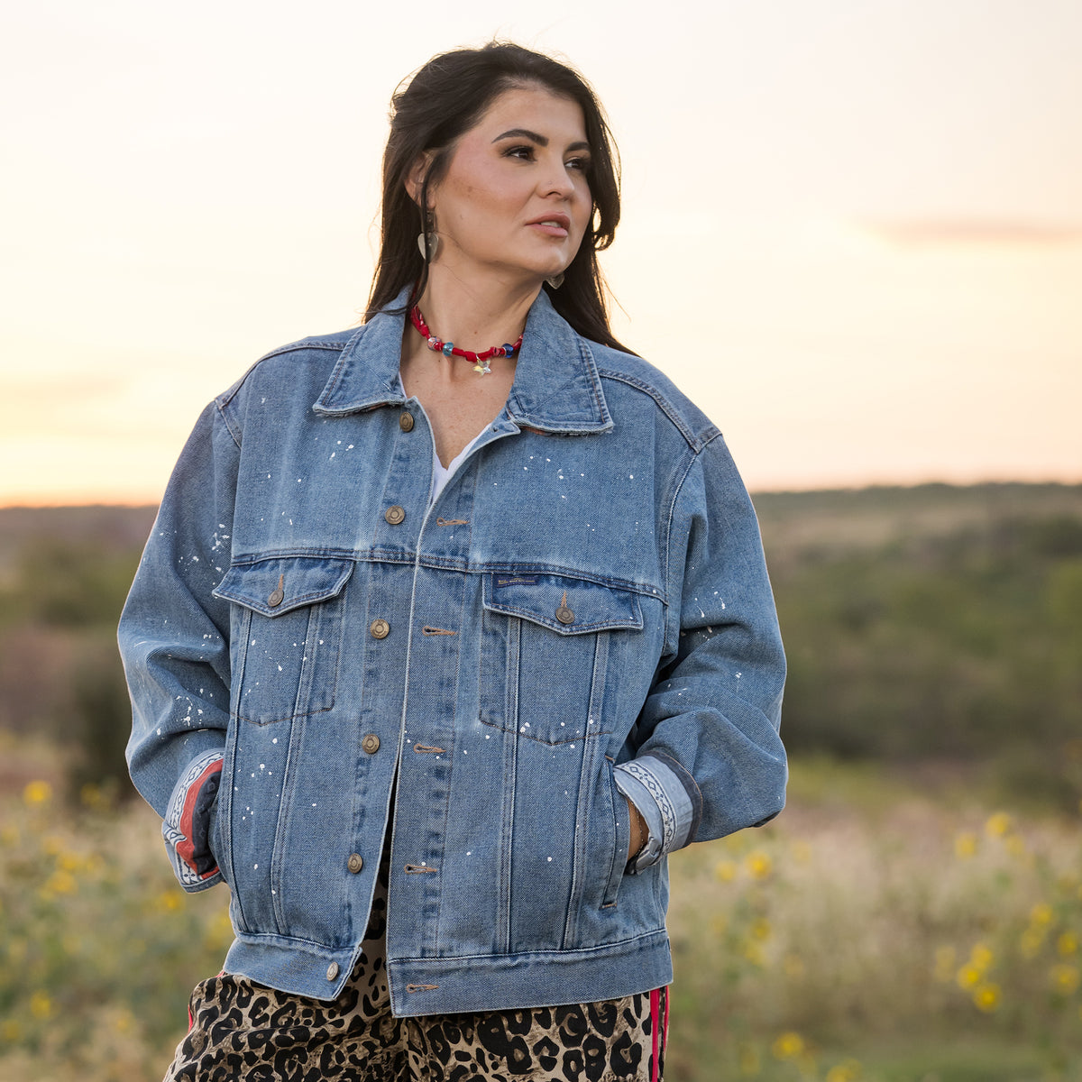 Whitney Vest wearing a spackled denim jacket in a field.