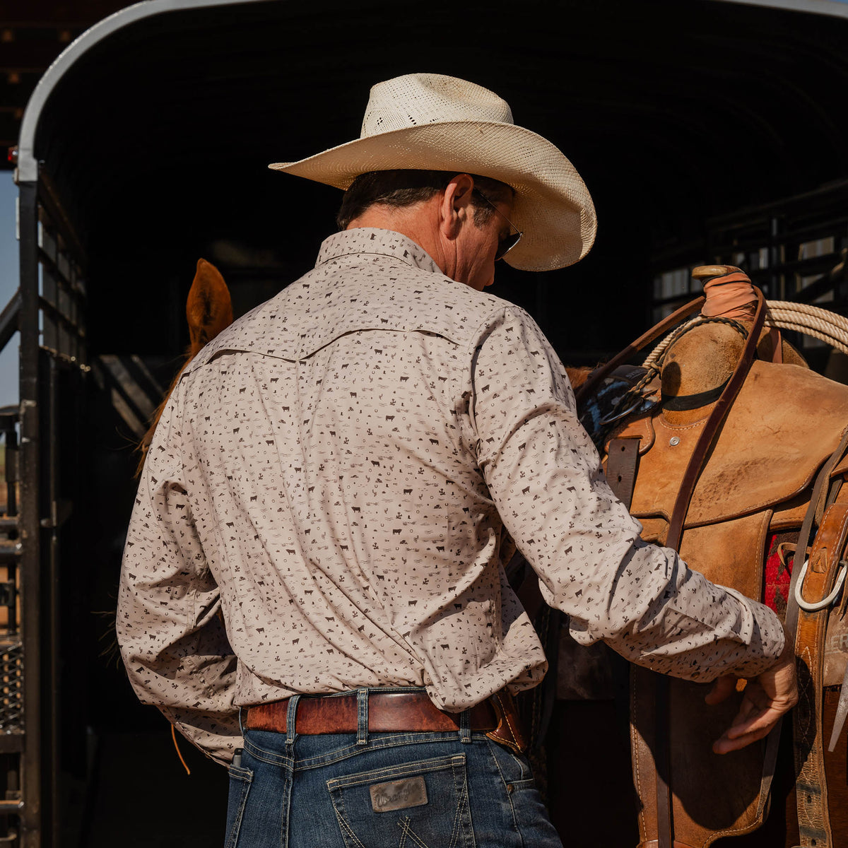 Man facing away wearing a white cowboy hat, jeans and khaki pearl snap long sleeve shirt.