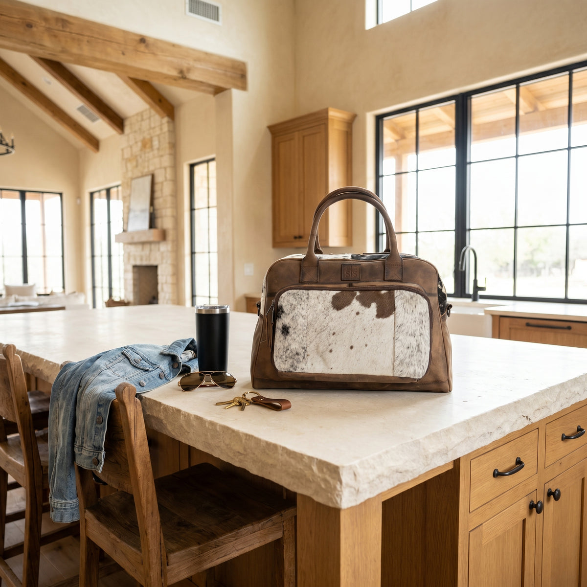 Brown leather bag with hair on hide cowhide accents on a kitchen counter.