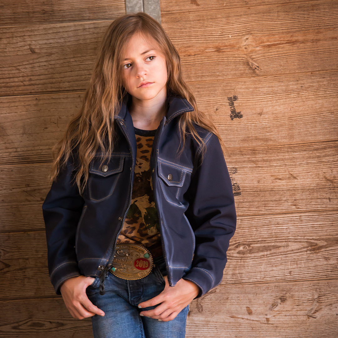 selah smith wearing our softshell dark wash denim jacket with front snap closure, hand warming pockets and chest pockets on wooden background
