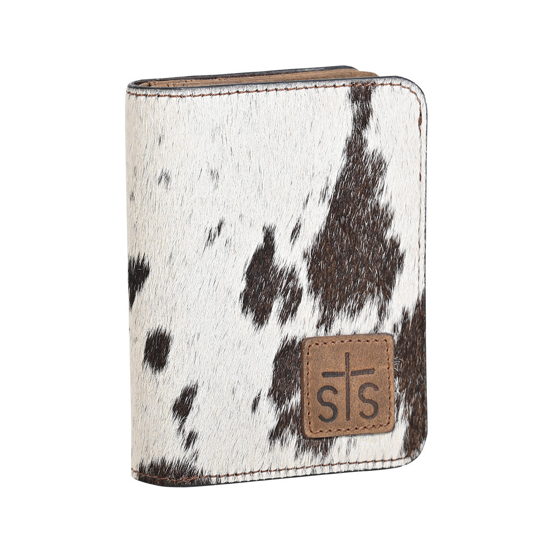 A wallet with brown and white hair on hide cowhide, zip around closure and brown leather patch with STS logo embossed on a white background.