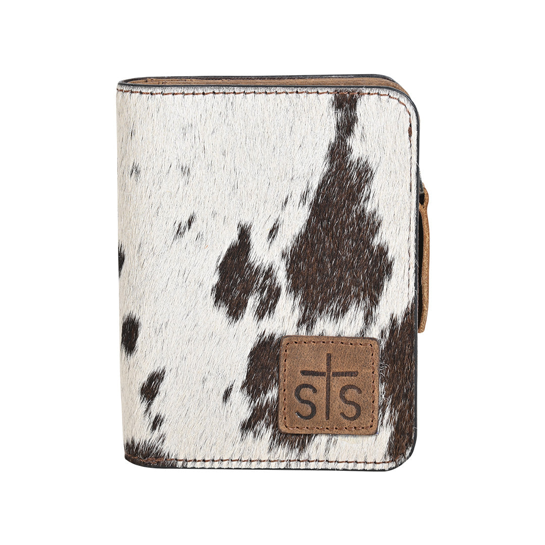 A wallet with brown and white hair on hide cowhide, zip around closure and brown leather patch with STS logo embossed on a white background.